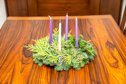 Advent wreath with four candles on a wooden table
