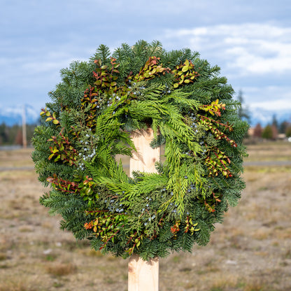 Green wreath on a wooden post with a blurred natural background